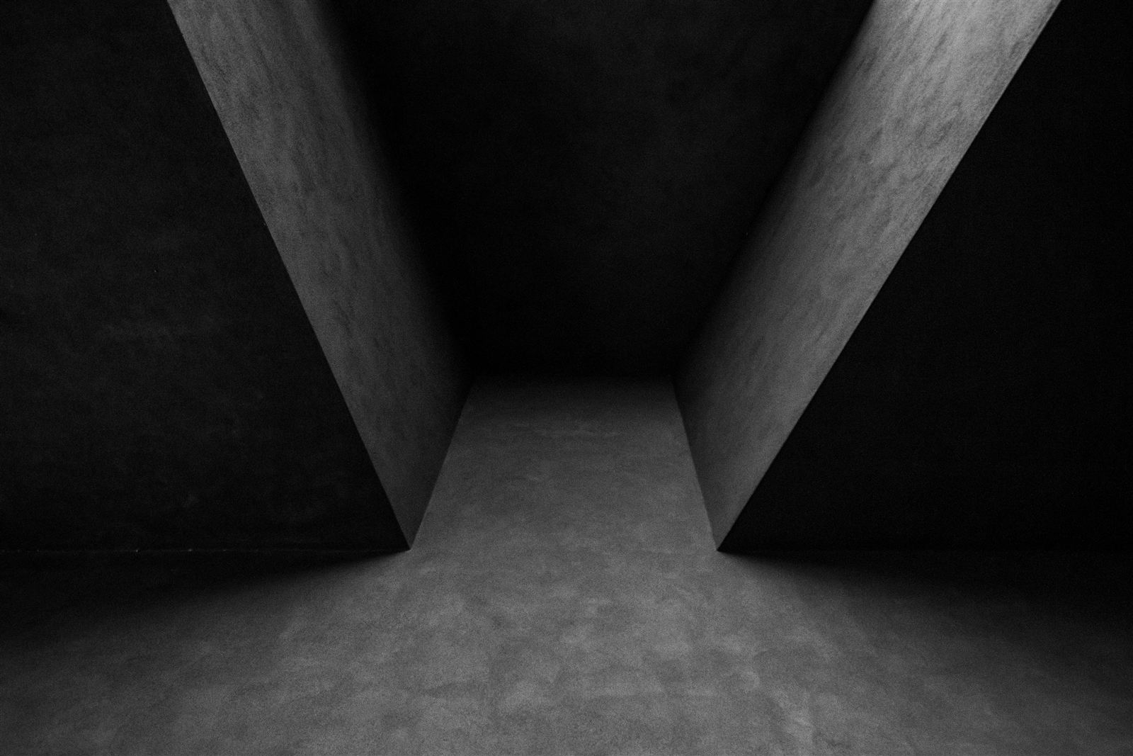 A dark corridor converging toward a lit vanishing point, evoking a confidential underwriting floor.